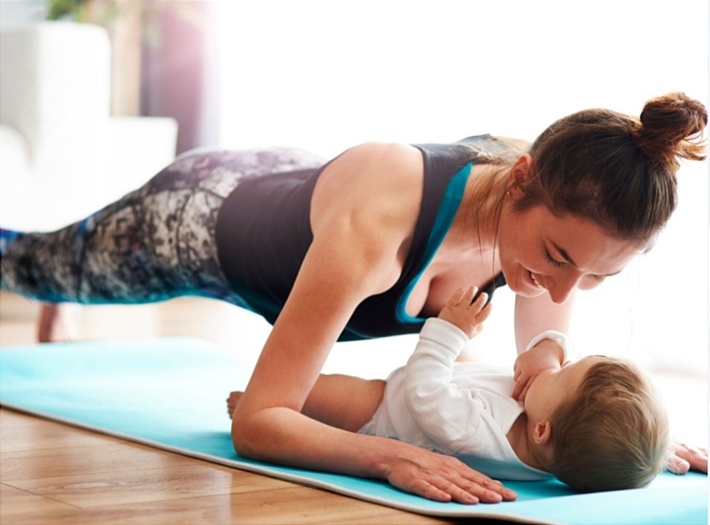 Une femme sur un tapis d’exercice, face à un bébé allongé